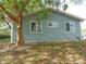Side view of home with blue siding, showcasing the manicured landscaping and mature trees at 10955 Sw 89Th Ave, Ocala, FL 34481