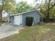 Side view of home with blue siding, featuring a garage and well-kept lawn at 10955 Sw 89Th Ave, Ocala, FL 34481