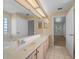 Elegant bathroom featuring double sinks, a large mirror, and neutral tiling at 11645 Sw 75Th Cir, Ocala, FL 34476