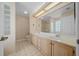 Well-lit bathroom showcasing a double vanity with a large mirror and a glass-enclosed shower at 11645 Sw 75Th Cir, Ocala, FL 34476
