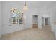 Charming dining room with decorative window, light fixture, and doorway leading to carpeted living area at 11645 Sw 75Th Cir, Ocala, FL 34476