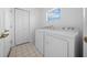 Efficient laundry room equipped with a side-by-side washer and dryer at 11645 Sw 75Th Cir, Ocala, FL 34476