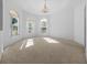 Bright and airy living room with neutral carpet, chandelier, and large arched windows at 11645 Sw 75Th Cir, Ocala, FL 34476