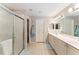 Spacious bathroom with dual sinks, large mirror, tiled floors, and walk-in shower providing comfort and style at 11828 Se 91St Cir, Summerfield, FL 34491