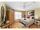 Inviting bedroom features wood floors, a ceiling fan, closet, and window with natural light at 11828 Se 91St Cir, Summerfield, FL 34491