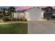 Charming home featuring a two-car garage, beautiful landscaping, and a cozy front patio at 11828 Se 91St Cir, Summerfield, FL 34491