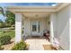 Inviting front porch with a decorative bench, a 'Welcome' flag, and a charming entrance, creating a warm atmosphere at 11828 Se 91St Cir, Summerfield, FL 34491