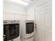 A dedicated laundry room features modern washer and dryer, plus practical shelving for storage at 11828 Se 91St Cir, Summerfield, FL 34491
