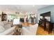 Spacious living room with hardwood floors, comfortable furniture, and an open layout connecting to the kitchen at 11828 Se 91St Cir, Summerfield, FL 34491