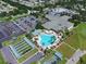 Aerial view of the community center, pool, parking, and sports courts amidst lush landscaping at 13109 Se 86Th Ct, Summerfield, FL 34491