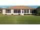 Home exterior featuring a screen enclosed lanai, well-maintained landscaping, and a lush lawn at 13109 Se 86Th Ct, Summerfield, FL 34491