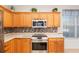 Kitchen features stainless steel appliances, tiled backsplash, and wood cabinetry at 13109 Se 86Th Ct, Summerfield, FL 34491