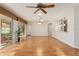 Bright living room with hardwood floors, ceiling fan, and views to a lanai at 13109 Se 86Th Ct, Summerfield, FL 34491