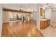 Open-concept living area with hardwood floors, a view of the lanai, and a breakfast bar at 13109 Se 86Th Ct, Summerfield, FL 34491