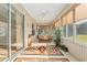Inviting sunroom featuring ample sunlight, neutral tones, a ceiling fan, and a decorative area rug at 13109 Se 86Th Ct, Summerfield, FL 34491