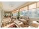Open sunroom featuring a seating area with wicker chairs and a decorative rug at 13109 Se 86Th Ct, Summerfield, FL 34491