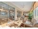 Expansive sunroom with ceiling fans, lots of bright windows, plants and comfortable seating, blending indoor and outdoor living at 13109 Se 86Th Ct, Summerfield, FL 34491