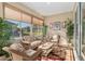 Relaxing sunroom with comfortable seating, bright windows, and lush plants, creating an inviting atmosphere for relaxation at 13109 Se 86Th Ct, Summerfield, FL 34491