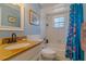 Bright bathroom featuring a tiled shower/tub combo, granite vanity, and soft blue walls at 13300 Ne 38Th Ave, Anthony, FL 32617