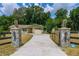 Gated entrance with lion statues on stone pillars leading to the house at 13300 Ne 38Th Ave, Anthony, FL 32617