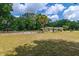 Front exterior view with large yard, mature trees, and partial horse paddock in view at 13300 Ne 38Th Ave, Anthony, FL 32617
