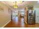 Inviting hallway featuring wood floors, neutral paint, decorative lighting, and access to multiple rooms at 13300 Ne 38Th Ave, Anthony, FL 32617
