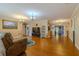 Spacious living room featuring wood floors, neutral paint, elegant chandeliers, and access to other rooms at 13300 Ne 38Th Ave, Anthony, FL 32617