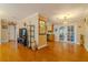 Open-concept living room featuring wood floors, neutral paint, glass display case, and access to other rooms at 13300 Ne 38Th Ave, Anthony, FL 32617