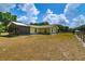 Back of home featuring a screened in porch, well-maintained yard, and partial stone foundation at 13300 Ne 38Th Ave, Anthony, FL 32617