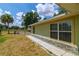 Side exterior view featuring large windows, stone foundation and expansive yard on a sunny day at 13300 Ne 38Th Ave, Anthony, FL 32617