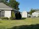 Side yard shows the detached shed with ample greenery at 137 Juniper Loop, Ocala, FL 34480