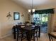 Dining room with a wooden table, chandelier, and sliding doors offering natural light at 137 Juniper Loop, Ocala, FL 34480