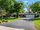 Charming single-story home with an expansive driveway and mature trees in a well-manicured front yard at 1505 Se 27Th Ter, Ocala, FL 34471
