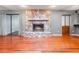Cozy living room with hardwood floors and a striking stone fireplace, perfect for gathering and relaxing at 1505 Se 27Th Ter, Ocala, FL 34471