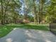 View of the house with a manicured lawn and mature trees from the backyard at 16 Northern Dancer Dr, Ocala, FL 34482