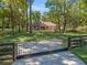Lovely ranch-style home featuring an iron gate, mature trees, and a well-maintained lawn at 16 Northern Dancer Dr, Ocala, FL 34482
