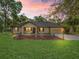 Inviting home with manicured lawn, front yard seating, and warm lighting creating a cozy ambiance at 16 Northern Dancer Dr, Ocala, FL 34482