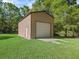 Detached one-car garage with a roll-up door and a side door in the backyard at 16 Northern Dancer Dr, Ocala, FL 34482