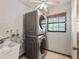 Functional laundry room with stacked washer and dryer, sink, and window at 16 Northern Dancer Dr, Ocala, FL 34482