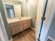 Bright bathroom featuring laminate floors, a vanity with ample storage space, and a doorway to another room at 16201 Sw 47Th Ter, Ocala, FL 34473