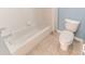 Neat bathroom featuring a white bathtub with tiled walls, a toilet, and neutral-toned flooring at 16201 Sw 47Th Ter, Ocala, FL 34473