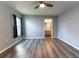 Bedroom with laminate flooring, a ceiling fan, natural light, and an en-suite bathroom at 16201 Sw 47Th Ter, Ocala, FL 34473