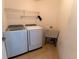 Functional laundry room featuring a washer, dryer, utility sink and wire shelving at 16201 Sw 47Th Ter, Ocala, FL 34473