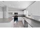 Well-lit kitchen boasting white cabinets, stainless steel appliances, gray countertops, and tile flooring at 1698 Ne 161 St, Citra, FL 32113