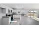 Spacious kitchen with white cabinets, stainless steel appliances, gray countertops, tile flooring, and access to the backyard at 1698 Ne 161 St, Citra, FL 32113