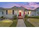 Charming single-story home featuring a welcoming front porch, well-manicured lawn, and a vibrant red front door at 1910 Se 28Th Pl, Ocala, FL 34471