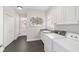 Convenient laundry room with a sink, white cabinets, and a stylish piece of art at 1910 Se 28Th Pl, Ocala, FL 34471