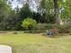A partial view of a backyard with an orange tree and a lawn at 19903 Sw 97Th Ln, Dunnellon, FL 34432