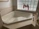 Bright bathroom showcasing large corner tub with window at 19903 Sw 97Th Ln, Dunnellon, FL 34432
