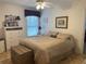 Cozy bedroom featuring a ceiling fan, dresser with decorative items, and a trunk at the foot of the bed at 19903 Sw 97Th Ln, Dunnellon, FL 34432